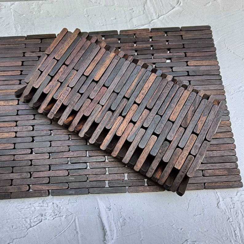 Two dark Sonokeling wood placemats made from connected rectangular blocks